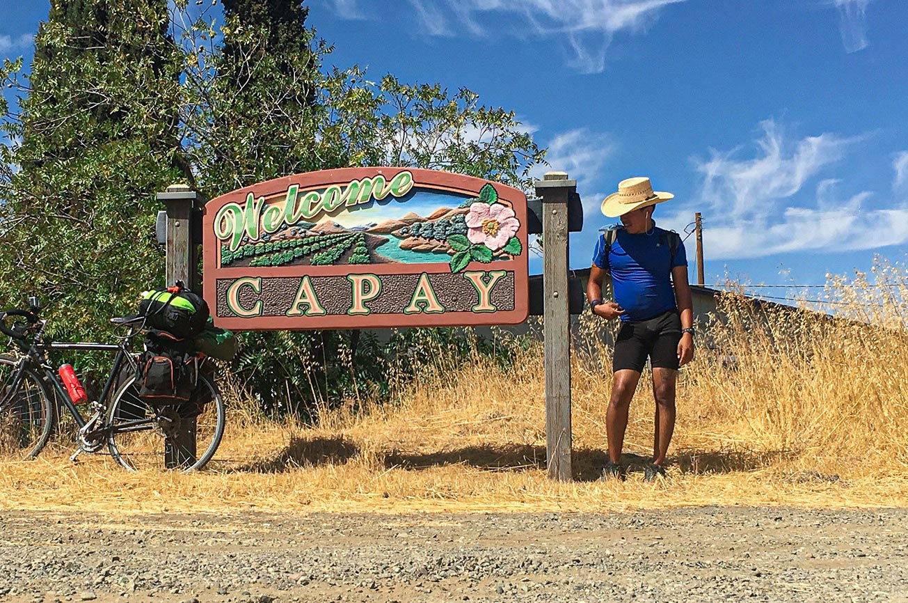 Team member Glenn standing by a Welcome sign
